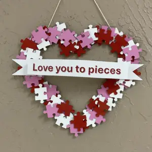 Heart-shaped puzzle piece wreath with text "Love you to pieces.", links to more information
