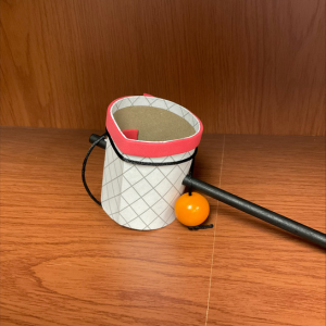 Basketball-themed fidget toy with a hoop and orange ball on a wooden surface, links to more information