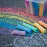 Colored chalk pieces and a rainbow drawing on a cement, links to more information