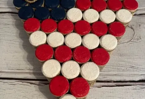 Photo of heart shaped flag made of red, white, and blue painted corks.