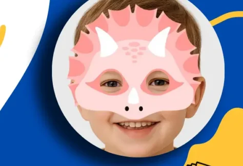 Blue and yellow background with Shawano County Library logo in lower corner. Photo of boy with pink dinosaur mask on his face.