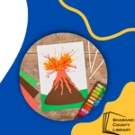blue and yellow background with photo of a volcano paper art with lava. Shawano County Library logo in the lower right corner.