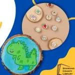 Blue background. Green dinosaur with a blue background on a wood magnet. Shawano County logo.