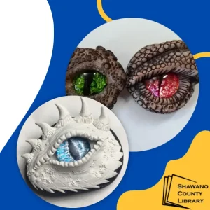 Blue background. Clay white and brown dragon eyes with green, red and blue eyes. Shawano County Library logo.
