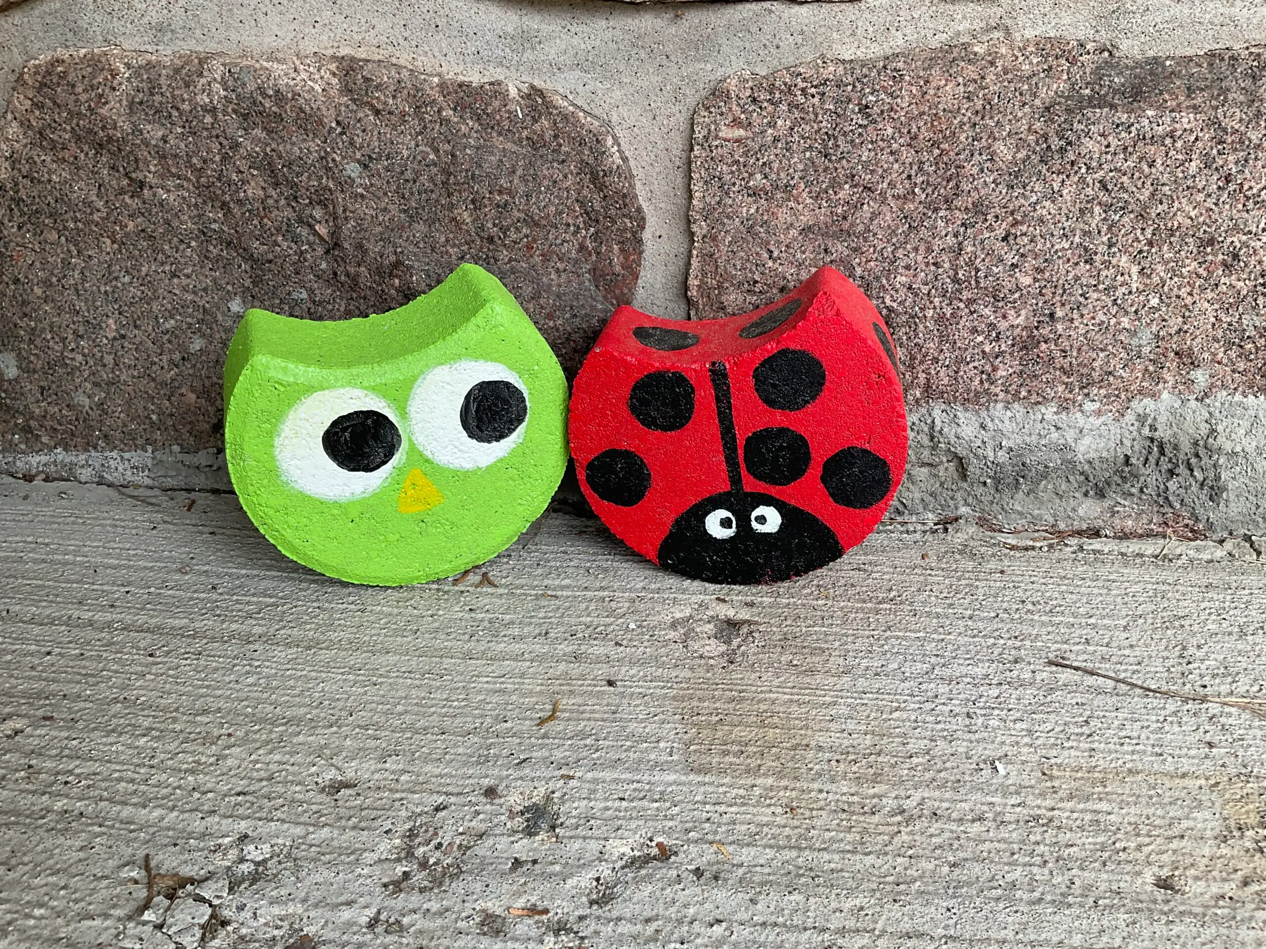 Image of a ladybug and an owl painted on concrete paving bricks