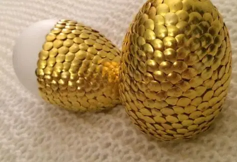 Styrofoam eggs covered with gold thumbtacks