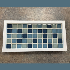 A grid of glass tiles in shades of blue and green, in a white tray, links to more information