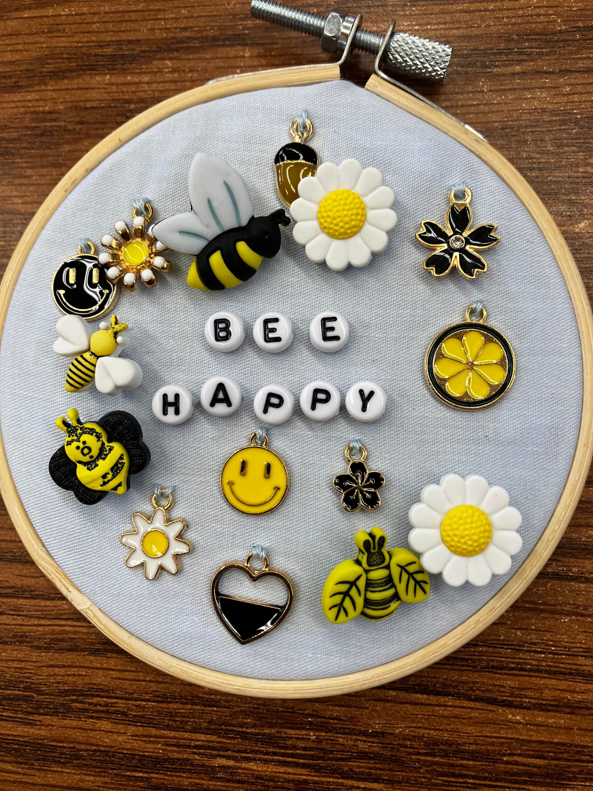 Image of an embroidery hoop with the words "bee happy' and various bee and flower beads