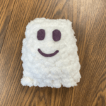 A small white knit ghost with felt eyes and a smile, links to more information