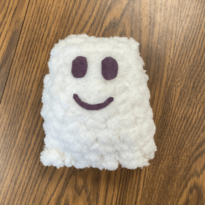 A small white knit ghost with felt eyes and a smile, links to more information