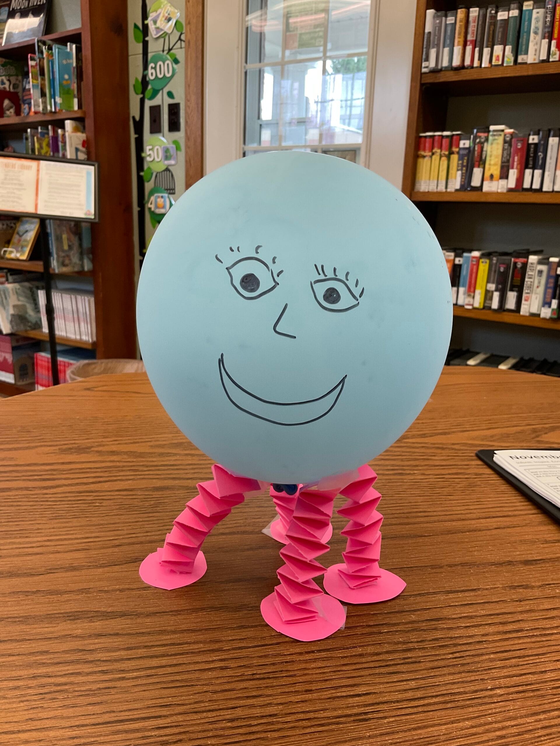 Image of a balloon with a face drawn on and paper legs