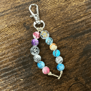 Colorful beaded keychain with a silver clasp on dark wood surface, links to more information